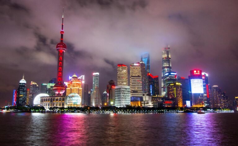 Captivating view of Shanghai's illuminated skyline reflecting on the waterfront at night.