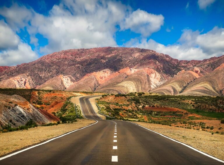 Winding road through vibrant landscapes and colorful mountains in Jujuy, Argentina.