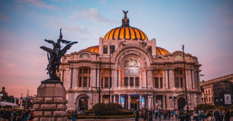 Vibrant sunset at the historic Palacio de Bellas Artes in Mexico City, bustling with tourists.
