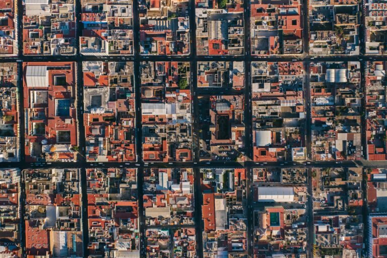 Drone aerial view capturing the intricate urban grid of Puebla, Mexico with vibrant rooftops.